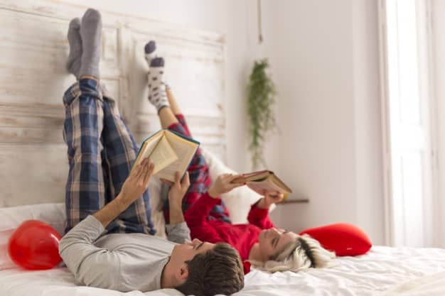 Couple enjoying a stay at home date by reading a book