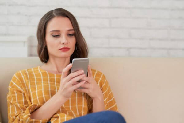 Woman staring sadly at her phone