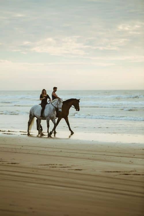 Couple Horse riding on a beach